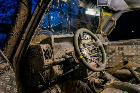 View of the mud-covered interior of an off-road vehicle featuring a steering wheel and metal floor panels in Sortavala, Respublika Kareliya, Russia.