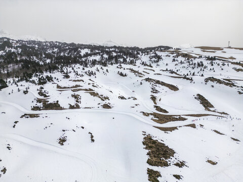 Aerial view of cross-country skiing tracks winding through snow-covered hills and pine forests in Isaba, Navarre, Spain.
