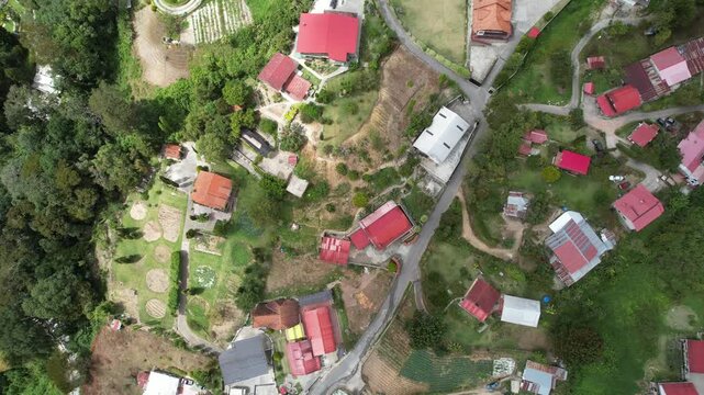 Aerial view of the village of Colonia Tovar with red-roofed houses and winding roads surrounded by lush green hills in Caracas, Miranda, Venezuela.