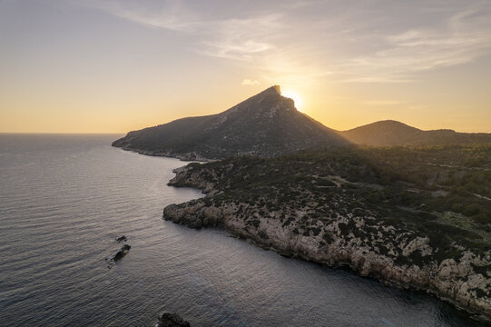 Aerial view of Port de Sa Dragonera at sunset with rocky cliffs and calm sea Islas Baleares, Spain.