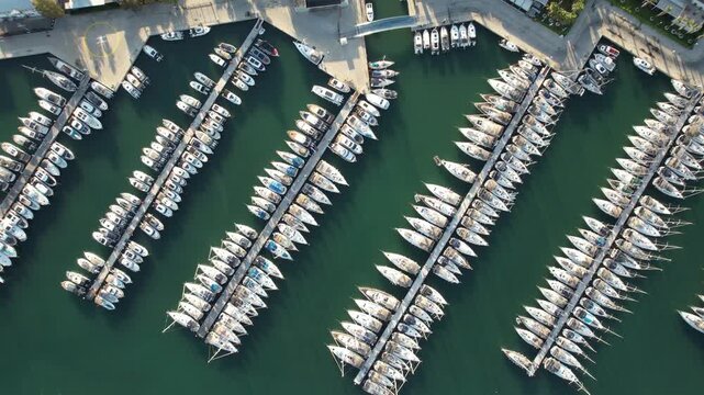 Aerial view of numerous sailboats and yachts docked in rows at the marina in Sigacik, Izmir, Turkiye.
