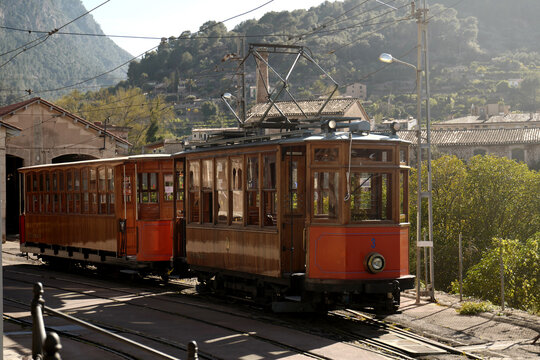 Port de Soller, Spain - 01 April 2018: View of the historic wooden tram at the Estacio de Tramvia with mountains in the background.