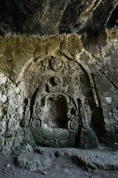 View of an ancient stone relief carving featuring intricate symbols and weathered textures inside a cave in Mallorca, Balearic Islands, Spain.