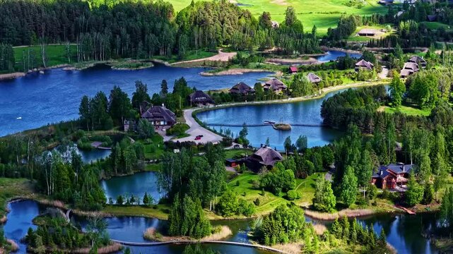 Aerial view of Amatciems village with wooden houses nestled among lakes and lush forests in Amatciems, Cesu novads, Latvia.