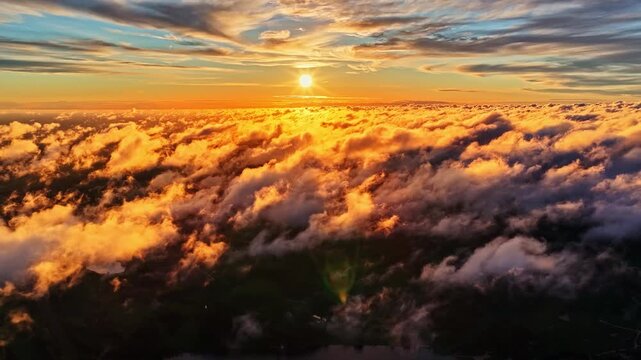 Aerial view of a vibrant sunset glowing above a thick layer of clouds in Amatciems, Cesu novads, Latvia.
