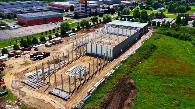 Aerial view of industrial construction site with steel frame structure and heavy machinery in Jelgava, Jelgava pilseta, Latvia.