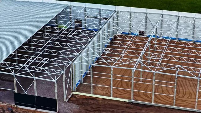 Aerial view of a large steel frame structure under construction with exposed metal beams and sandy ground in Jelgava, Jelgava pilseta, Latvia.