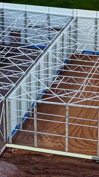Aerial view of the steel frame structure of a new building under construction on a muddy site in Jelgava, Jelgava City, Latvia.