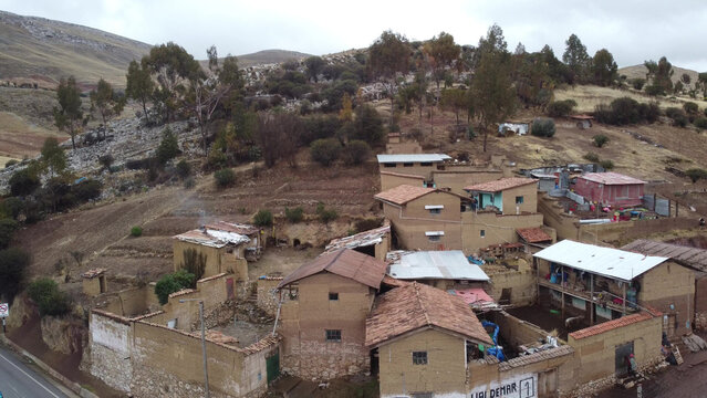 Aerial view of the rural village of San Mateo with traditional adobe houses, terracotta tiled roofs, and terraced hillsides in the Andean landscape of San Mateo, Gobierno Regional de, Peru.