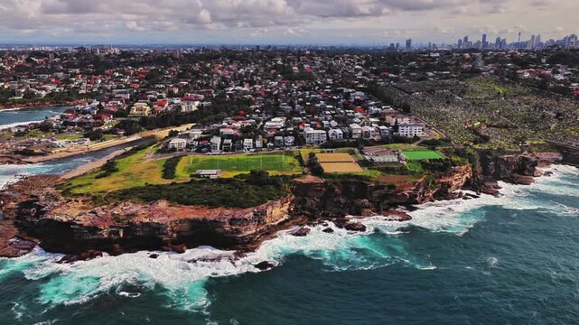 Aerial view of Waverley Cemetery overlooking the rugged coastline and residential area of Bronte, New South Wales, Australia.