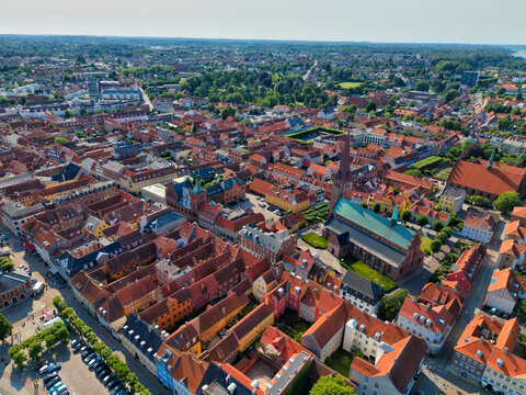 Aerial view of Saint Olaf's Church surrounded by historic red-tiled rooftops, narrow streets, and lush greenery in the town of Helsingor, Denmark.