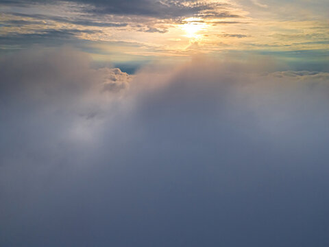 Aerial view of sunset light illuminating thick cloud layers over the landscape of Vidzeme, Latvia.
