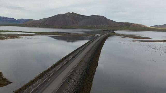 Aerial view of the road crossing Kolgrafarfjordur fjord with mountains in the background in Bjarnarhofn, Grundarfjardarbaer, Iceland.