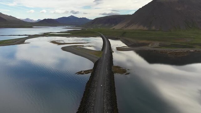 Aerial view of the Kolgrafarfjordur road bridge crossing the calm waters with surrounding mountains in Bjarnarhofn, Grundarfjardarbaer, Iceland.