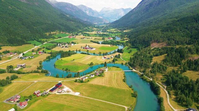 Aerial view of the meandering river flowing through the green valley and rural landscape of Stryn, Vestland, Norway.