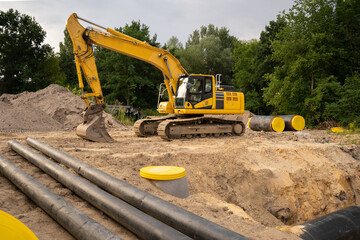 A yellow excavator is working at the construction site © Олеся Матвеева