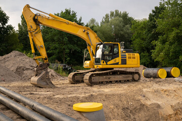 A yellow excavator is working at the construction site © Олеся Матвеева