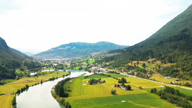 Aerial view of the river flowing through the green valley of Stryn surrounded by mountains in Stryn, Vestland, Norway.
