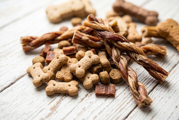 Fototapeta premium Pile of bone shaped dog biscuits and braided treats on a table