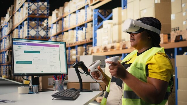 African American woman uses a VR system to process orders and track parcel shipments, combining hands-free inventory control, virtual reality technology and artificial intelligence for fast delivery.