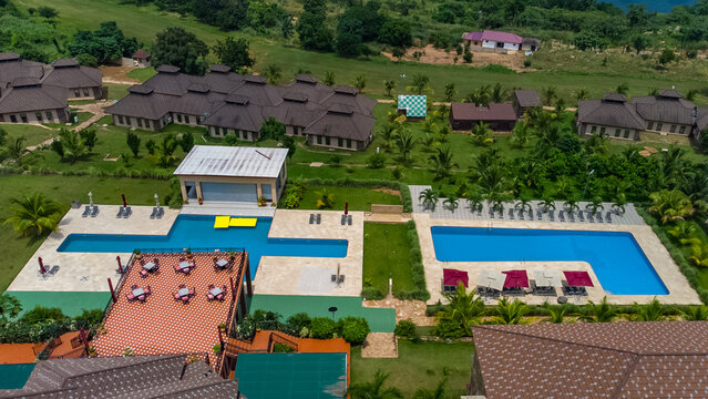 Akosombo, Eastern Region, Ghana - 11 September 2022: Aerial view of The Peninsula Resort with swimming pools, lounge areas, and lush green grounds.