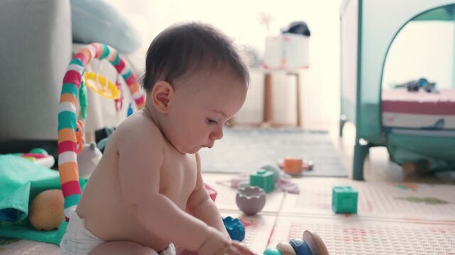 Curious baby boy playing with educational wooden toys at home