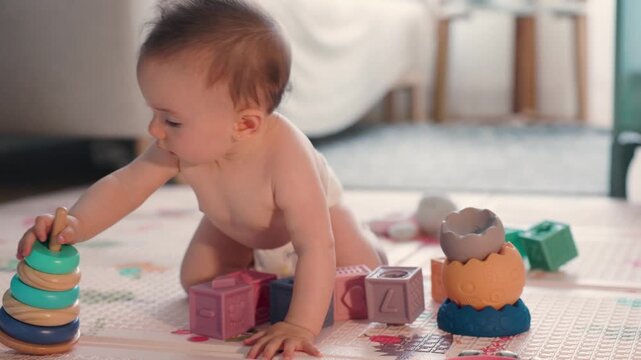 Curious baby girl crawling and playing with toys