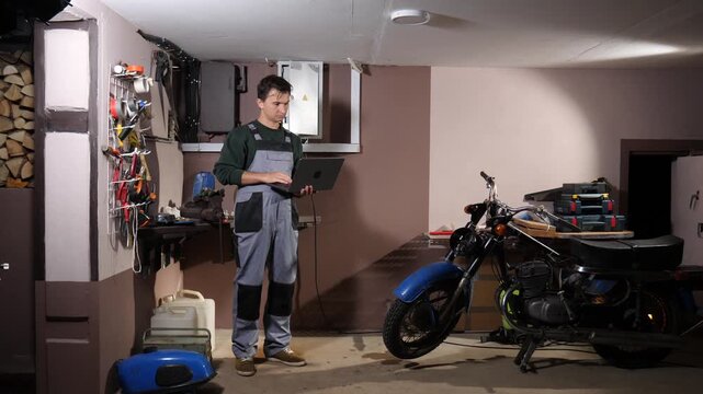 Professional mechanic performing diagnostic work on a vintage motorcycle, utilizing a laptop computer to analyze vehicle data and ensure proper maintenance in a workshop setting