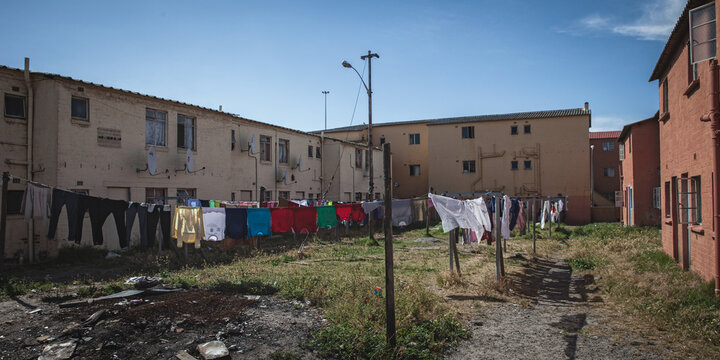 Cape Town, South Africa - 14 July 2026: View of a residential area in a township with laundry hanging on lines between low-rise buildings under a clear blue sky.