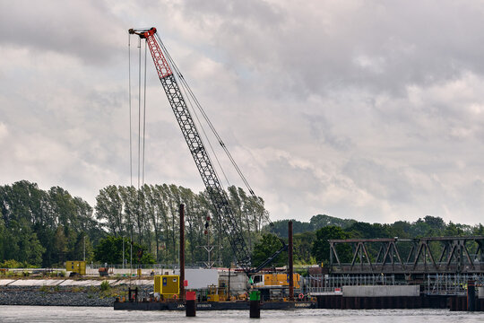 Rieseby, Germany - 02 July 2026: View of the Lindaunisbrucke renovation works featuring a large construction crane on a barge and a temporary footbridge over the water.