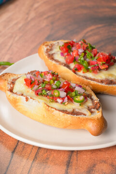 Toasted baguette slices with refried beans, melted cheese and pico de gallo topping. Mexican molletes