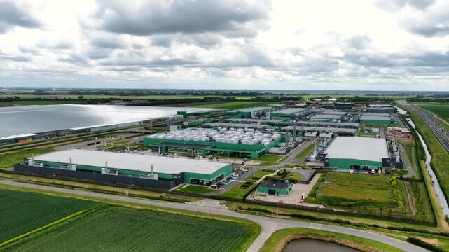 Aerial view of a large industrial data center complex surrounded by green fields and infrastructure in Middenmeer, Noord Holland, Netherlands.