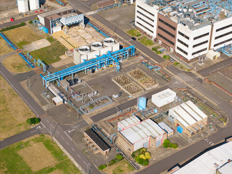 Aerial view of the Humber Innovation Park featuring industrial buildings, cooling towers, and complex piping systems within a paved facility in Grimsby, England, United Kingdom.