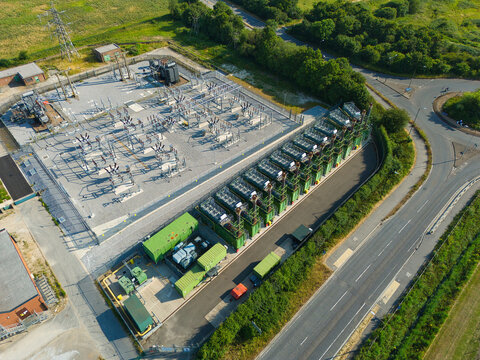 Aerial view of an electrical substation and containerized industrial generator compressor units situated near a road in Immingham, England, United Kingdom.