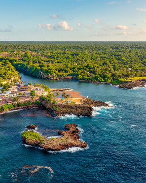 Aerial view of the coastal village of Boca de Yuma, featuring rocky cliffs, lush tropical vegetation, and turquoise Caribbean waters in Boca de Yuma, La Altagracia Province, Dominican Republic.