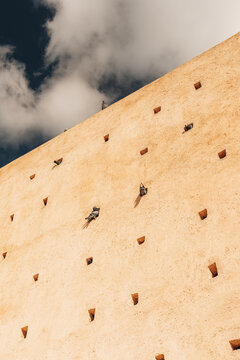 Rabat, Morocco - 14 November 2025: View of the historic textured wall with small square pigeon holes and perched pigeons under a blue sky.