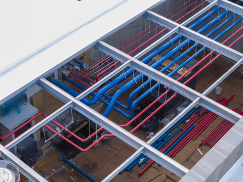 Aerial view of industrial cooling system pipes in blue and red installed on a building roof in Krakow, Lesser Poland Voivode, Poland.