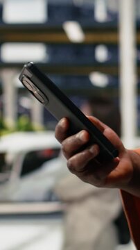Vertical frame: Passenger reviews bus ticket information on a smartphone before departure; the traveler looks up the ticket online while waiting in the bus station.