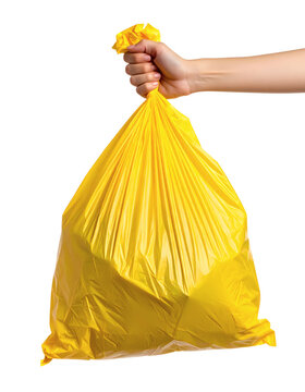 Hand holding yellow plastic garbage bag for waste collection and disposal in a studio shot showing a simple household chore for cleaning up residential clutter