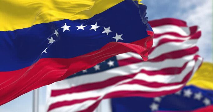Venezuela and US national flags waving in the wind on a clear day