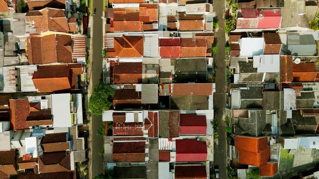 Aerial view of dense residential neighborhood with red-tiled rooftops and narrow streets in Singosari, East Java, Indonesia.
