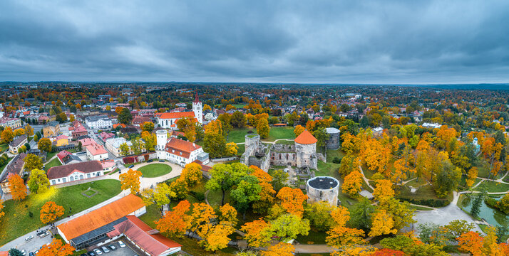 Aerial view of Cesis Castle surrounded by vibrant autumn foliage and historic town buildings in Cesis, Cesis Municipality, Latvia.