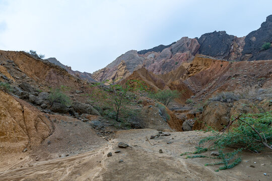 View of the rugged, arid landscape of the Sulaiman Mountains with rocky slopes, deep earth tones, and sparse desert vegetation in De-excluded Area Dera Ghazi Khan, Punjab, Pakistan.