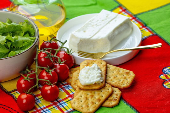 Cracker in primo piano con formaggio italiano a pasta molle , insalata e pomodori 