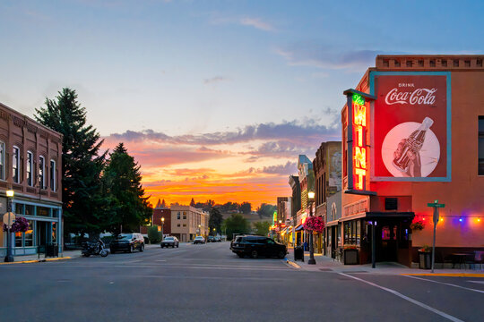 Evening view of the illuminated historic Main Street through the central historic downtown, part of the Livingston Business Improvement District, in Livingston Montana, USA, July 23 2026.