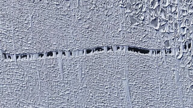 Aerial view of frozen landscape with a large fissure in the ice Latvia.