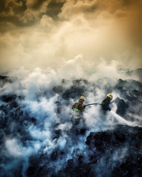 Aerial view of firefighters working to extinguish a fire at the Vertedero Duquesa landfill with thick smoke rising into the sky in Pantoja, Santo Domingo, Dominican Republic.