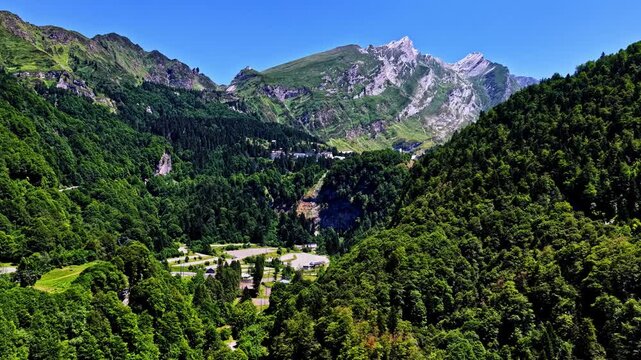 Aerial view of Col d'Aubisque surrounded by dense green forests and rugged mountain peaks in the Pyrenees, Beost, Nouvelle-Aquitaine, France.