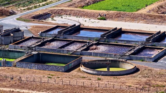 Aerial view of wastewater treatment plant with concrete aeration basins and circular clarifiers in Capbreton, Nouvelle-Aquitaine, France.