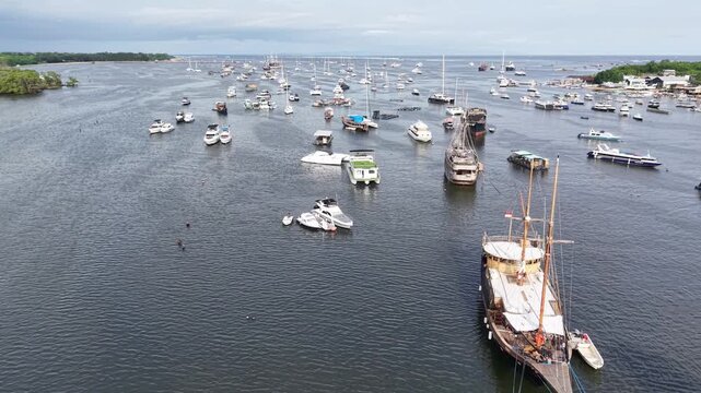 Aerial view of Island Harbor Serangan filled with numerous boats and yachts anchored in the calm waters of Kecamatan Denpasar Selatan, Bali, Indonesia.